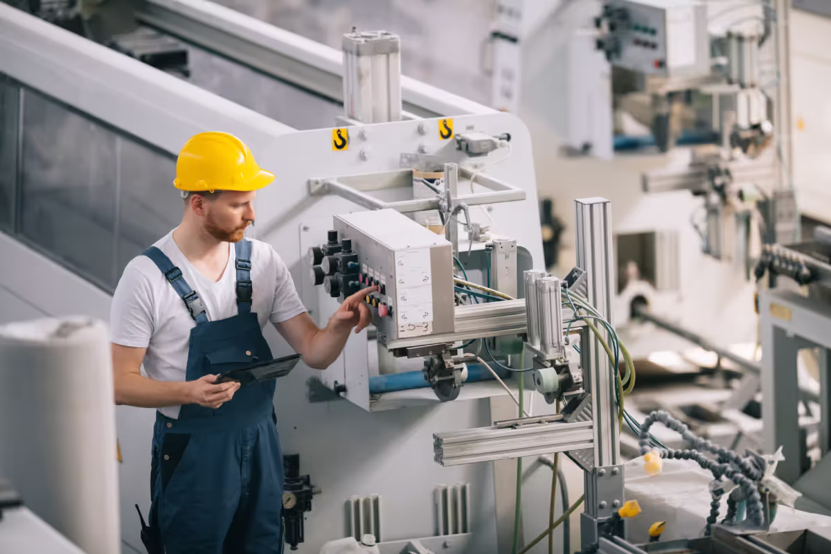 Man with helmet working in factory.